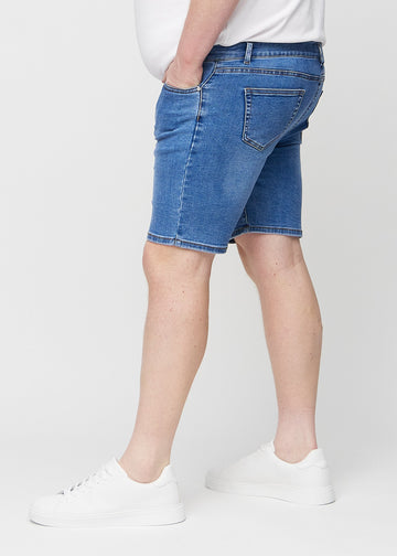 Denim middle-slim shorts seen from the side on a plus-size model.