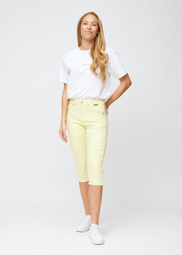 Fuldt billede af model iført lysegule slim capris.