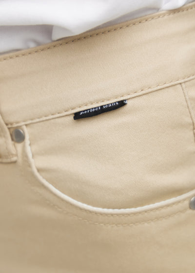 Forlommen på et par beige regular jeans, hvor man kan se logoet.