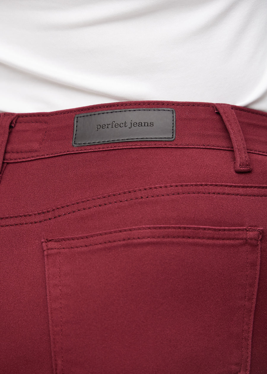 Baglommen på et par mørkerøde slim jeans, hvor man kan se logoet på en plus-size model.