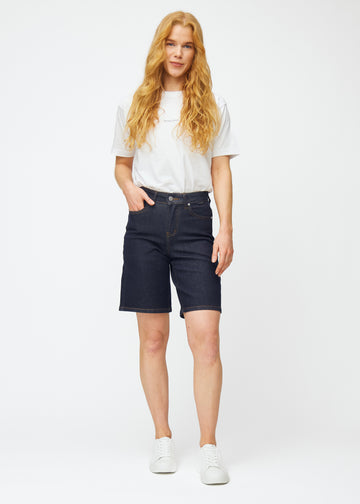Model viser dyb mørkeblå denim shorts til kvinder i farven Midnights med loose pasform i bevægelse.